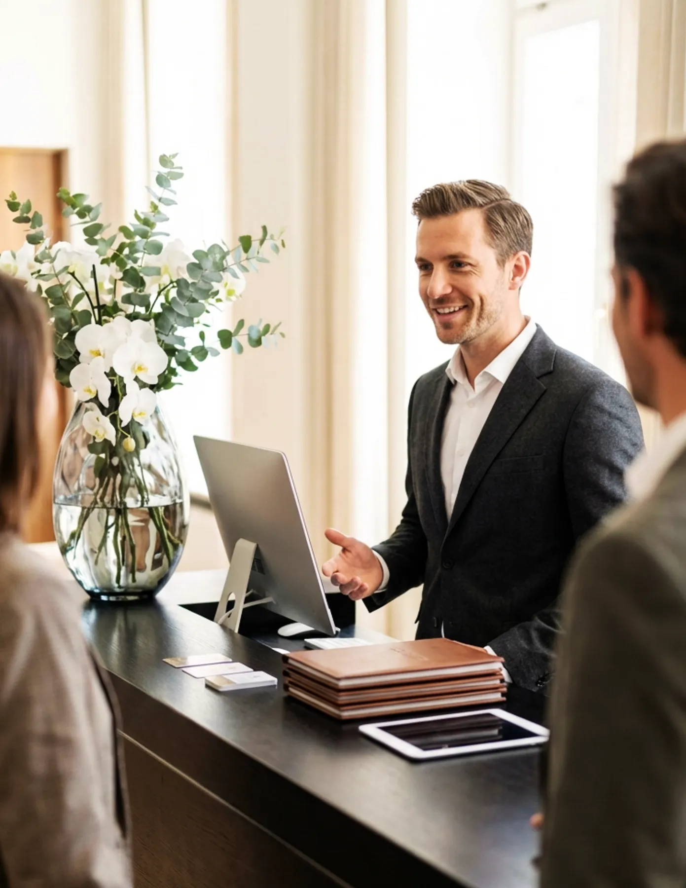 Front desk hospitality staff assisting visitors