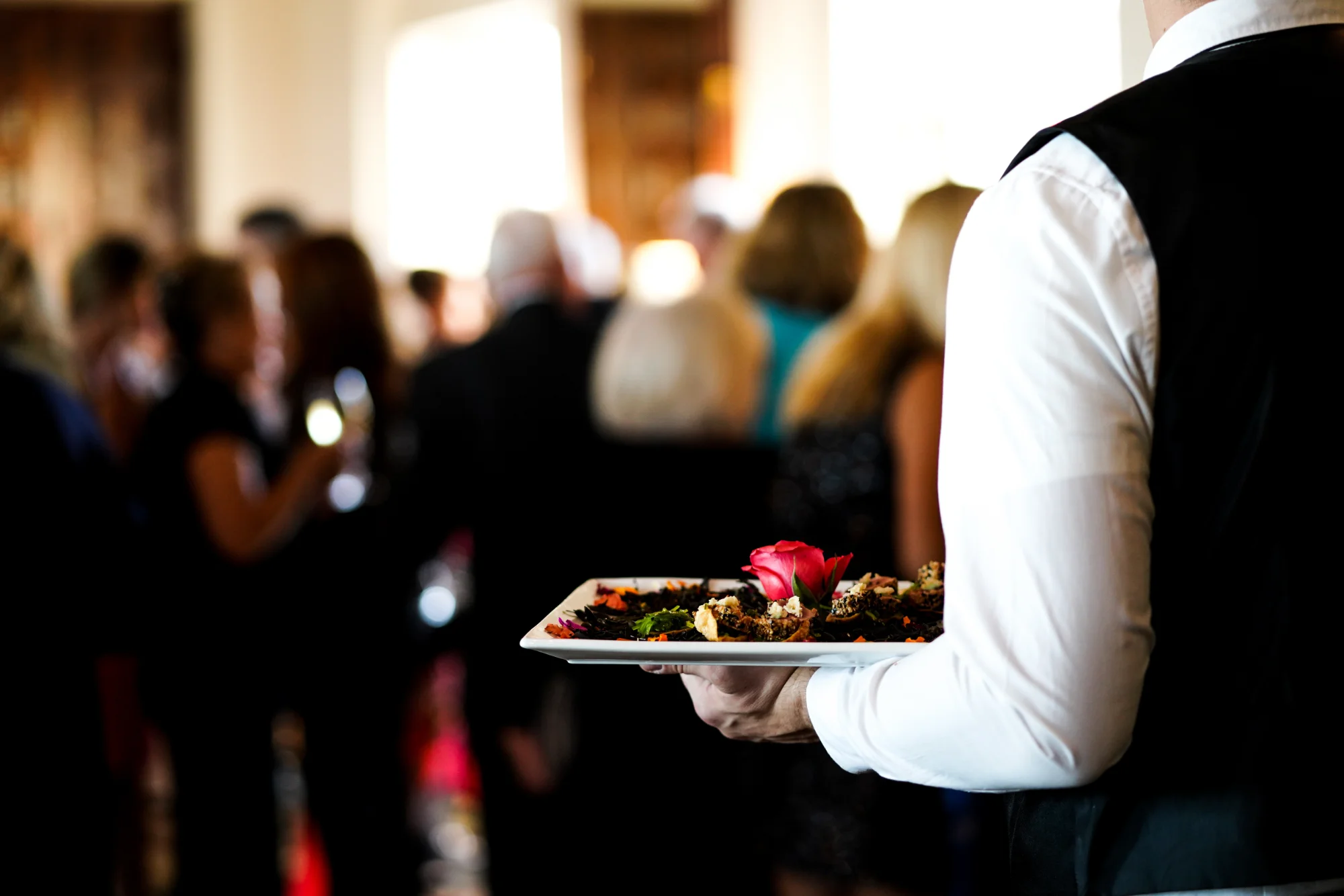 Closeup of a waitress holding a plate while serving at a large event like the Fifa World Cup.